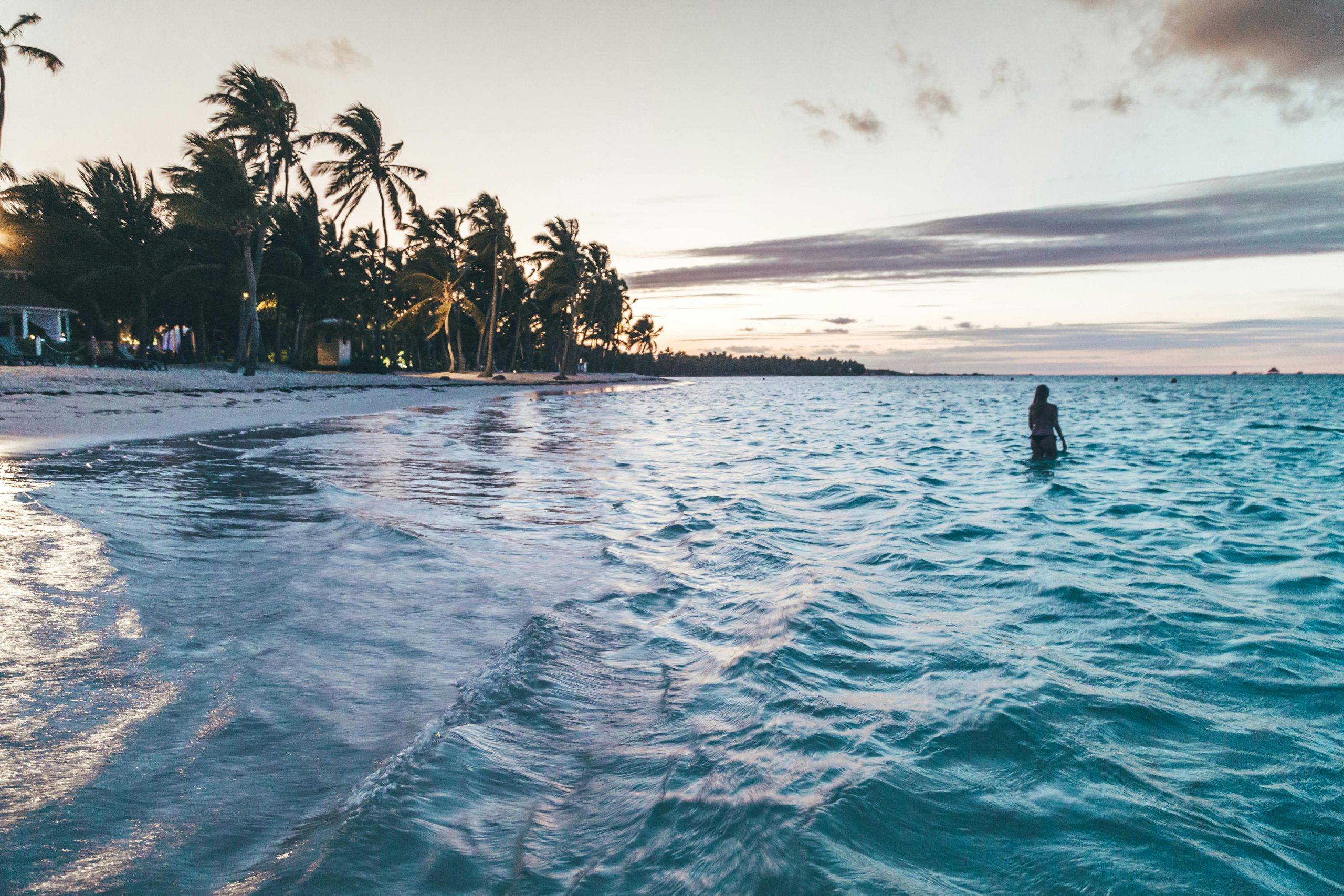 Silhouette on a tranquil beach in Punta Cana during twilight, capturing a peaceful tropical scene.