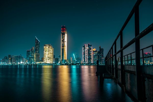 Stunning Abu Dhabi skyline at night with city lights reflecting off the calm waterfront.