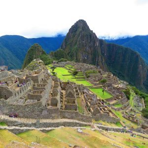 Stunning aerial perspective of Machu Picchu with lush surroundings under a cloudy sky.